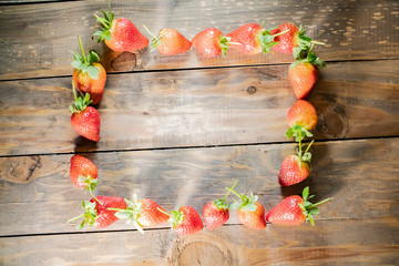 frame from strawberry berries close up on a wood background