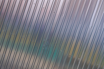 Obraz premium Silver tin iron wall with vertical and diagonal stripes from a metal profile of a metal sheet. Texture, background