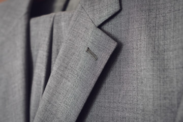 Fragment of light grey woolen suit. Selective focus.