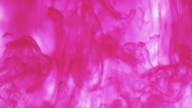 Purple magenta ink paint drops in water slow motion abstract background. Smoke cloud swirl, splash, mix and dissolve underwater