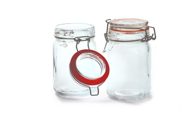 a collection of glass jars with lids and a bottle isolated on white