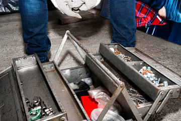 Taking tools from the tool box. The man holds a metal box in his hand, opens and gets the tools for work. The concept of physical work, repairs.