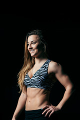 Obraz premium Happy strong woman looking away on black background