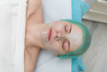 beautiful young woman with natural moisturizing mask on the face. Beauty treatment. Anti-aging skin...