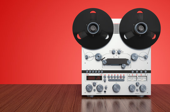 Retro reel-to-reel tape recorder on wooden background. 3D rendering