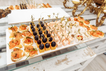 Different snacks on wooden tray near the bar