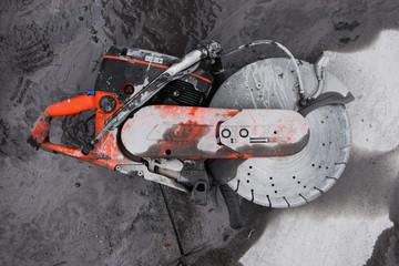 Concrete cutter machinery and cutting blade on a driveway