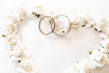 Obraz na płótnie Canvas Wedding rings cushion. Heart shape flowers. Marriage bride and groom jewelry. Symbol of love background.