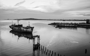 muelle en lago en calma con atardecer en blanco y negro