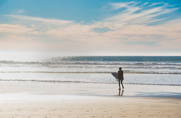 Naklejka premium Surfer on the shore of the famous Pismo beach in California.