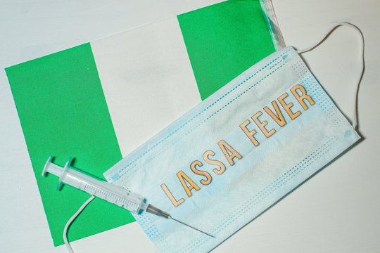 Nigerian flag under words Lassa fever outbreak concept. protective breathing mask and syringe. Lassa hemorrhagic fever LHF endemic in West Africa including Sierra Leone, Liberia, Guinea and Nigeria