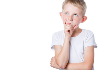 little boy holds his hand near chin, looks forward
