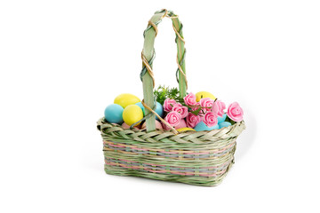 a wicker basket of colorful Easter eggs isolated on white
