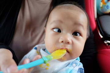 Asian boy with strabismus and eating food.
