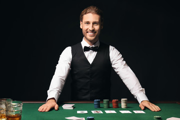 Young male banker at table in casino - obrazy, fototapety, plakaty
