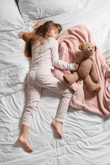 Cute little girl sleeping in bed