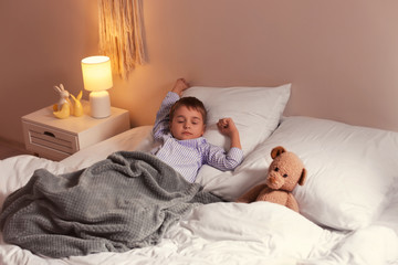 Cute little boy sleeping in bed