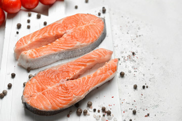 Raw salmon steaks and spices on table