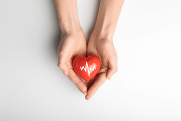 Female hands with red heart on white background. Cardiology concept