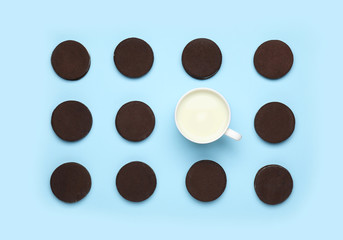 Tasty chocolate cookies with cup of milk on color background