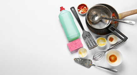 Dirty empty dishes with detergent and sponge on white background