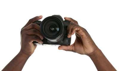 Hands of African-American photographer with camera on white background