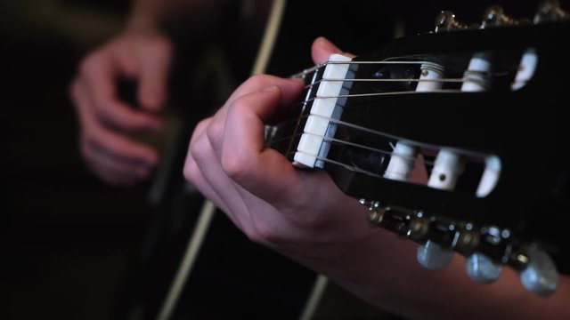 Concept of music and art. Concept. Close-up of man's hands playing on black acoustic guitar