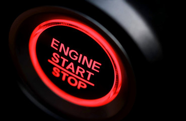 The driver's hand is pressing the car start button. Concept of transportation and technology