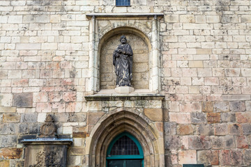 Statue on the wall of the Die kreuzkirche church, a gothic style building  in Hannover, Germany.