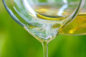Pouring olive oil in the a glass bowl at stone kitchen and inside green garden view. Prepare for cooking concept. Healthcare and Beauty Concept.