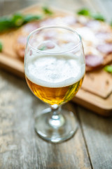 Freshly brewed beer and pepperoni pizza in bar. Selective focus. Shallow depth of field.