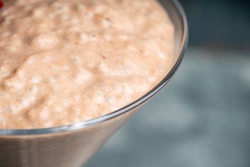 Chocolate yogurt with chia seeds and strawberry in martini glass on the rustic wooden background. Selective focus.