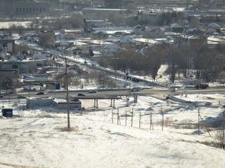 Fototapeta na wymiar View of the city of Ust-Kamenogorsk (Kazakhstan). Winter landscape. One of the streets. Traffic. Aerial. Grunge Landscape. Urban background