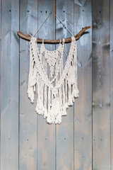 Handmade stylish cotton macrame decoration. Copy space.boho home interior decor,macrame wall hanging decoration, cozy stylish room.cotton threads in natural color using the macrame technique for home