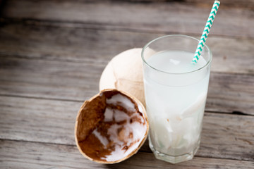 Fresh coconut juice in a glass with coconut white meat isolated on white