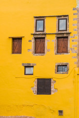 Fototapeta na wymiar Warm yellow facade with rustic windows