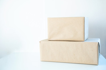 pile of two corrugated cardboard carton parcels box stacked on table and white wall background.