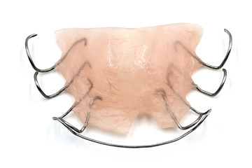 A removable orthodontic appliance isolated on white background. Concept of pediatric dentistry, correcting the bite. Closeup, large depth of field.