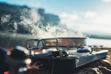 camping cooking in nature outdoor, prepare breakfast picnic in mist morning; vapours metal gas...