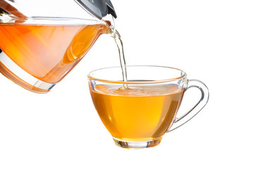 Pour the yellow tea or herbal tea into the glass. Isolated on white background
