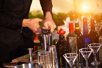 Close up of a delicious cocktail bartender putting slice of orange on. Bartender is making cocktail at bar counter