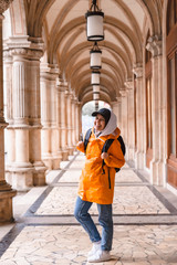 woman tourist walking with backpack in yellow raincoat city tourism