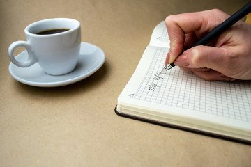 Writing in a notebook My life is a nearby cup of coffee