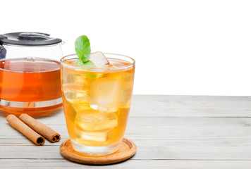 Tea or yellow herbal in a glass with ice And Peppermint added a fragrance on the wooden table Isolated on white background