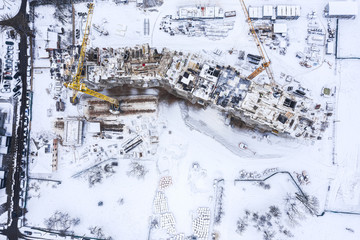 aerial top view of city construction site in winter. new apartment building under construction