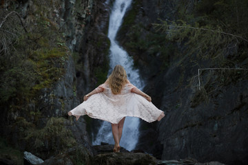 Girl on the background of a waterfall