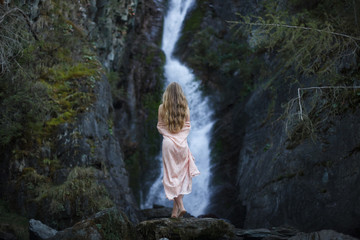 Girl on the background of a waterfall