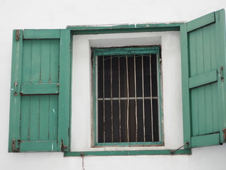 Open green wood old window on white wall, Retro house