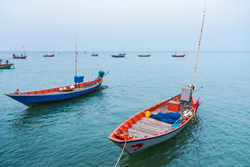 Naklejka na ściany i meble Floating fishing boats aground at the harbor over cloudy sky at Chanthaburi, Thailand.