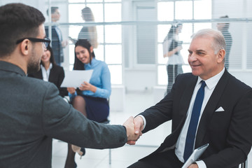 business colleagues shake hands sitting in the conference room
